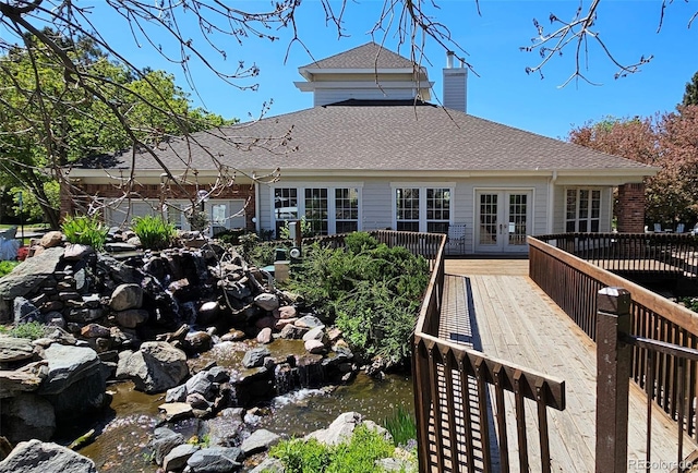 13873 E Lehigh Ave Unit E, Aurora, CO 80014 - rear view of house featuring french doors, a deck, a shingled roof, and a chimney