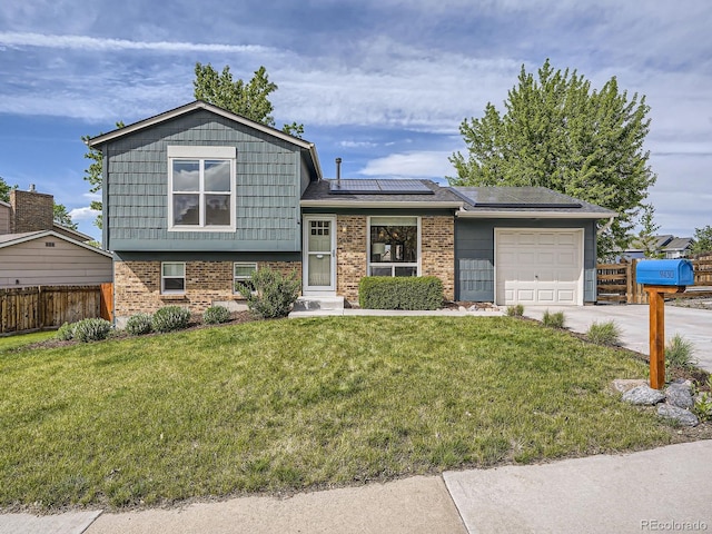 9430 Carr St, Westminster, CO 80021 - split level home with brick siding, a garage, roof mounted solar panels, and concrete driveway