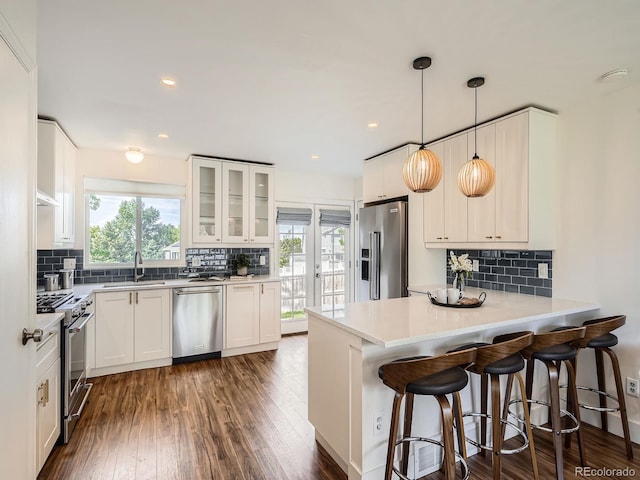 9430 Carr St, Westminster, CO 80021 - kitchen with high quality appliances, a peninsula, plenty of natural light, tasteful backsplash, and recessed lighting