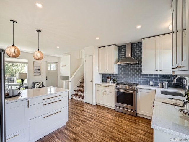 9430 Carr St, Westminster, CO 80021 - kitchen featuring stainless steel range, wall chimney range hood, a sink, tasteful backsplash, and hanging light fixtures