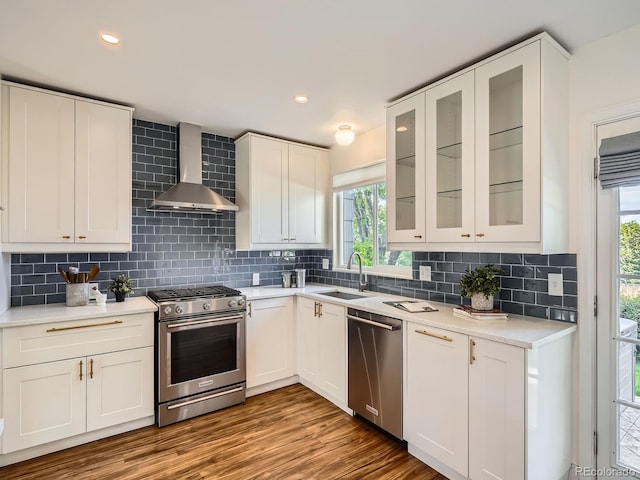 9430 Carr St, Westminster, CO 80021 - kitchen with stainless steel appliances, wall chimney range hood, a sink, healthy amount of natural light, and recessed lighting