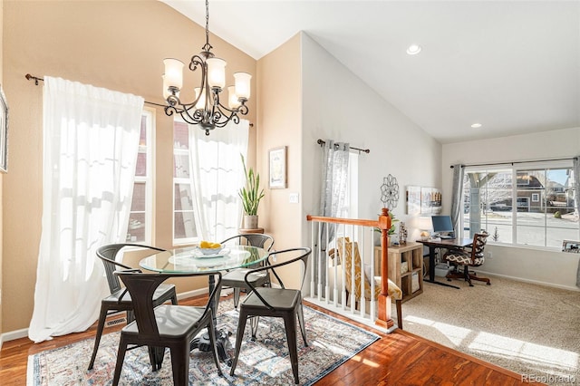 dining area featuring baseboards, vaulted ceiling, an inviting chandelier, and wood finished floors