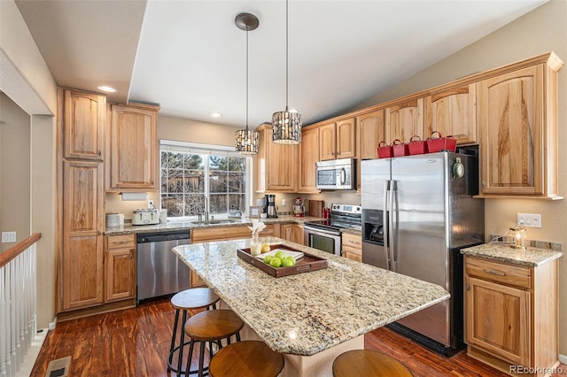 kitchen featuring a breakfast bar area, dark wood-type flooring, visible vents, appliances with stainless steel finishes, and light stone countertops