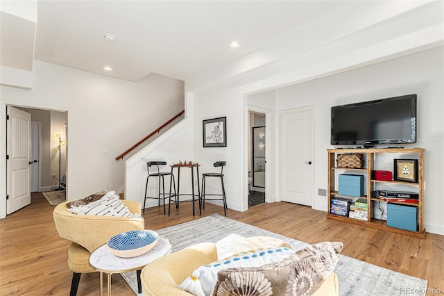 living room featuring baseboards, wood finished floors, and recessed lighting