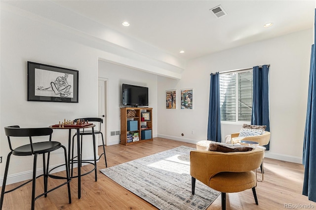 living area with light wood-type flooring, visible vents, baseboards, and recessed lighting