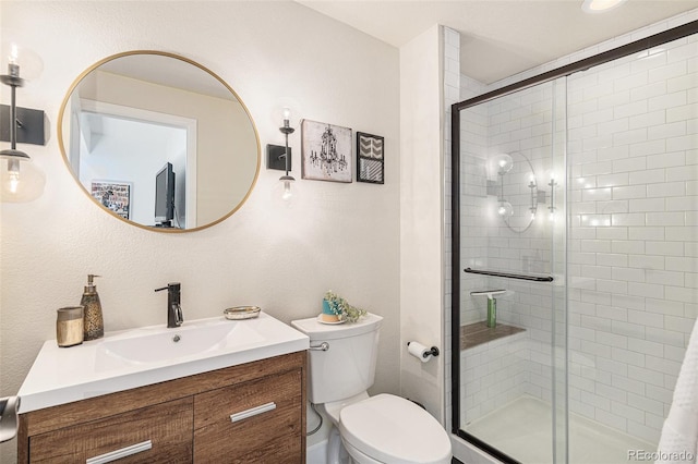 bathroom featuring vanity, a shower stall, and toilet