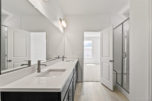 bathroom with hardwood / wood-style floors, vanity, and a shower with shower door