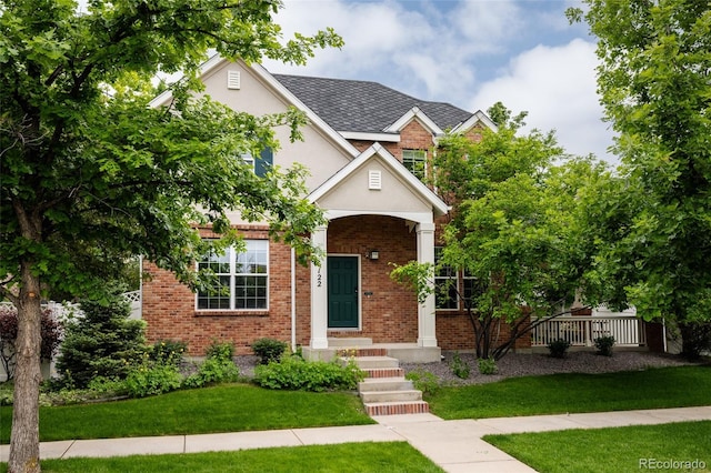 8122 E 6th Pl, Denver, CO 80230 - view of front of home featuring a front lawn, brick siding, and stucco siding