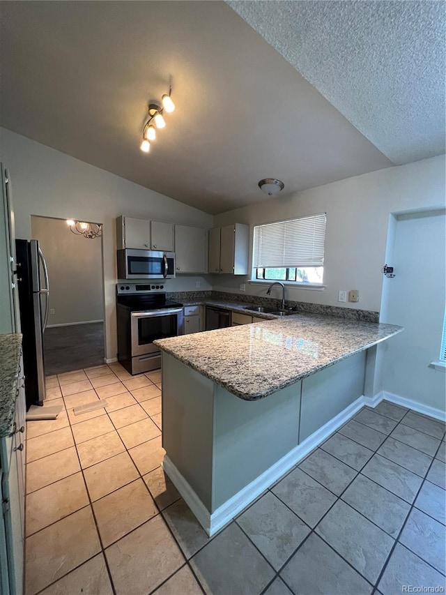 kitchen featuring gray cabinetry, appliances with stainless steel finishes, sink, kitchen peninsula, and vaulted ceiling