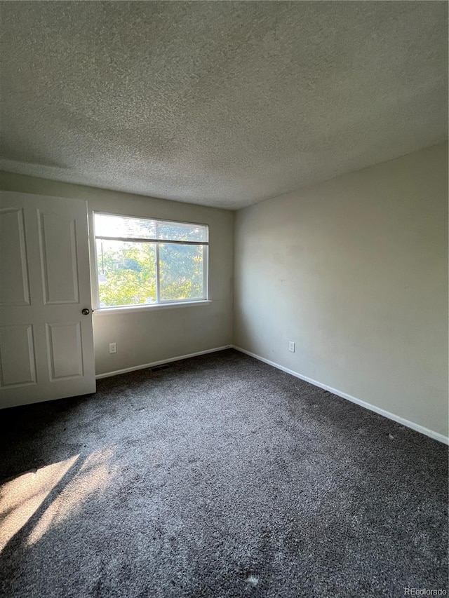 carpeted spare room with a textured ceiling