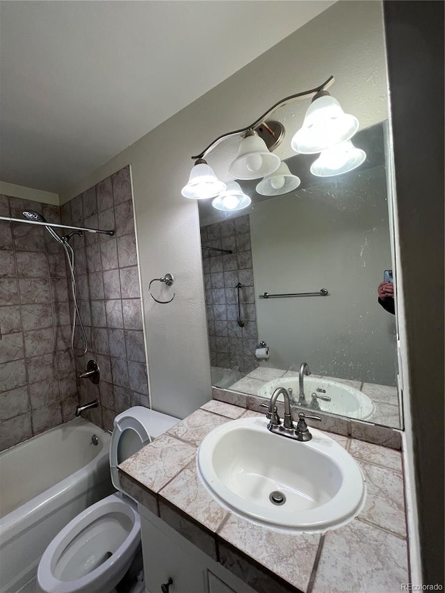 full bathroom with toilet, tiled shower / bath, and vanity