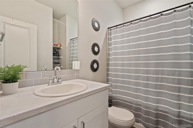 bathroom with tasteful backsplash, vanity, and toilet