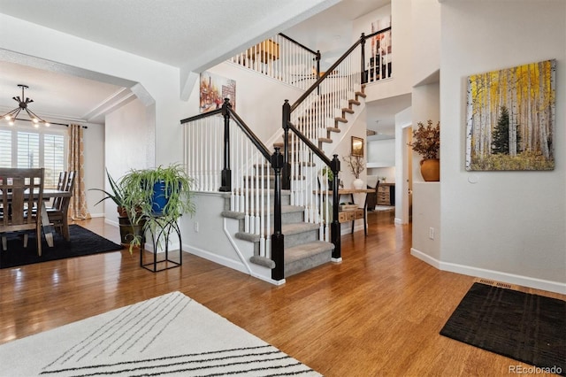 entrance foyer featuring wood-type flooring and a chandelier