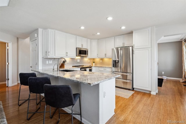 kitchen featuring white cabinetry, sink, a kitchen bar, kitchen peninsula, and stainless steel appliances