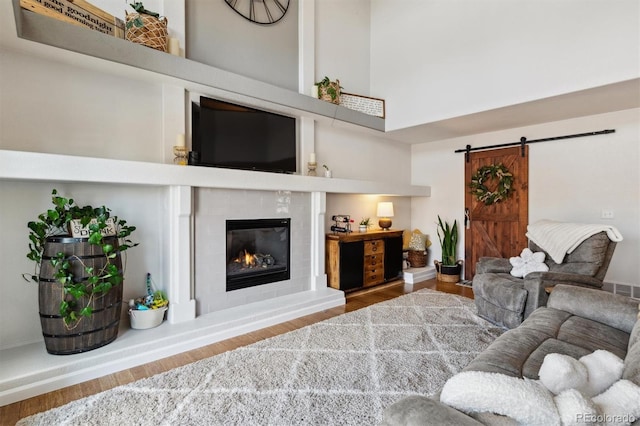 living room featuring a barn door, hardwood / wood-style floors, and a high ceiling