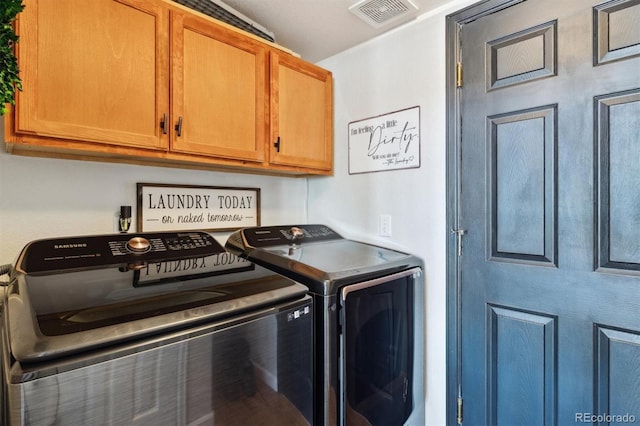 laundry room featuring washing machine and dryer and cabinets