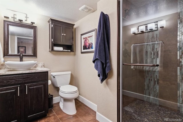 bathroom featuring vanity, walk in shower, toilet, tile patterned floors, and a textured ceiling