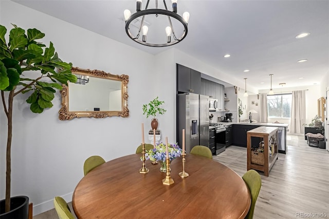 dining space with recessed lighting, light wood-style floors, and a chandelier