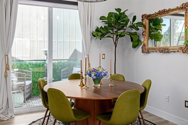 dining space with light wood finished floors and baseboards