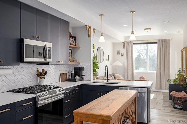 kitchen featuring a sink, open shelves, tasteful backsplash, stainless steel appliances, and a peninsula