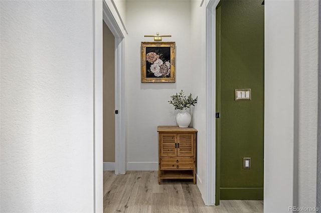 hallway with baseboards and light wood finished floors