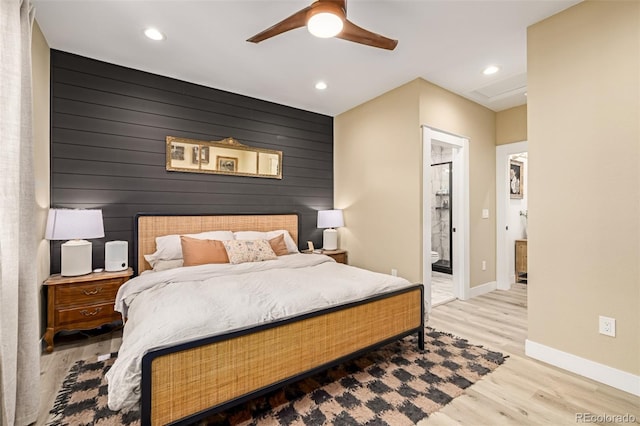 bedroom featuring an accent wall, recessed lighting, baseboards, and light wood-type flooring