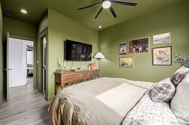 bedroom featuring a ceiling fan, wood finished floors, and visible vents