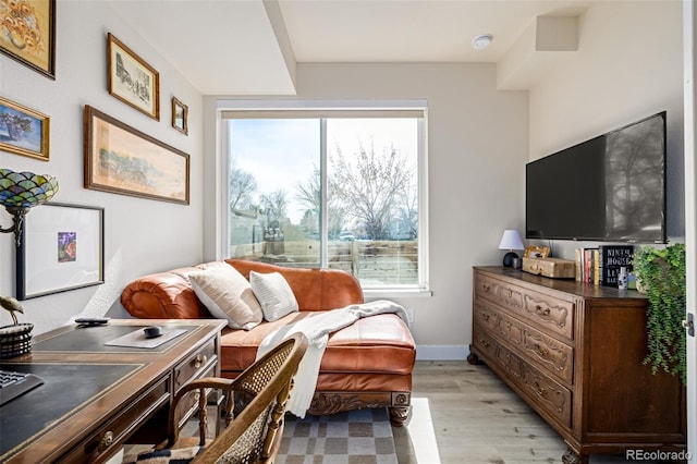 sitting room featuring baseboards and light wood-type flooring