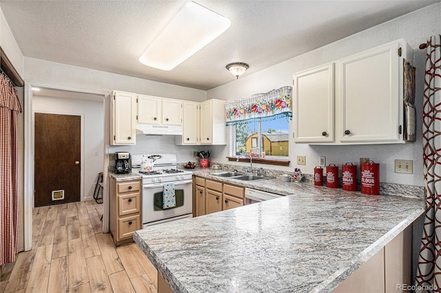 34181 Columbine Trl, Elizabeth, CO 80107 - kitchen featuring white gas range oven, under cabinet range hood, a peninsula, light wood-style flooring, and light countertops