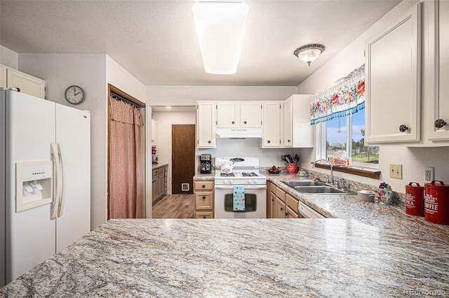 34181 Columbine Trl, Elizabeth, CO 80107 - kitchen with white appliances, under cabinet range hood, light countertops, a textured ceiling, and a peninsula