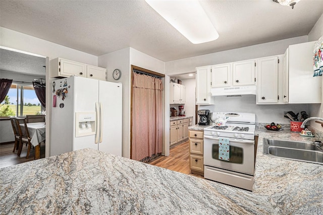 34181 Columbine Trl, Elizabeth, CO 80107 - kitchen with white appliances, under cabinet range hood, light wood-style flooring, white cabinets, and a textured ceiling