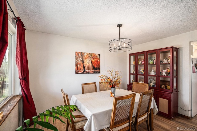 34181 Columbine Trl, Elizabeth, CO 80107 - dining space featuring wood finished floors, a chandelier, and a textured ceiling