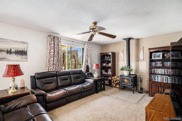 34181 Columbine Trl, Elizabeth, CO 80107 - tiled living room featuring a wood stove, a ceiling fan, a textured ceiling, and carpet