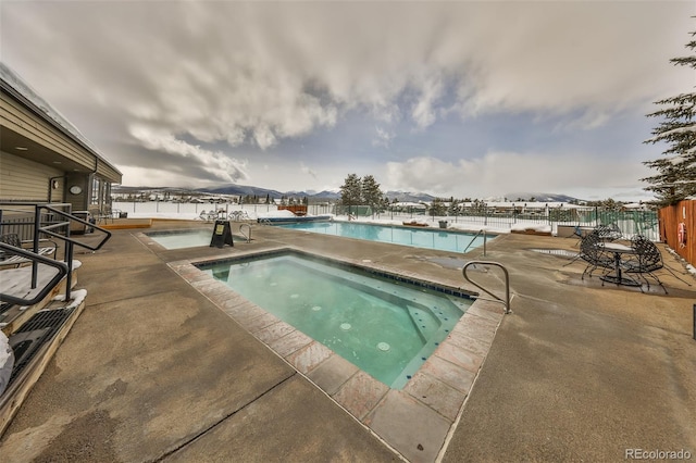 community pool with a community hot tub, a patio area, and fence