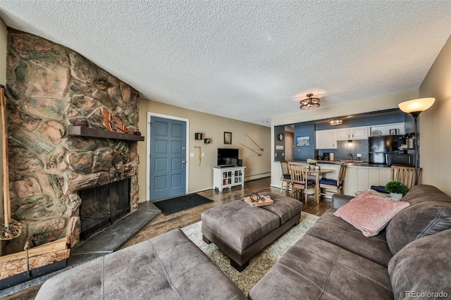 living room featuring a stone fireplace and a textured ceiling