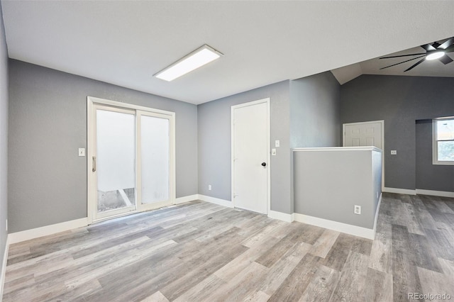 unfurnished room featuring light hardwood / wood-style flooring, vaulted ceiling, and ceiling fan