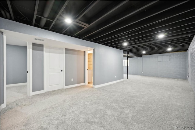 basement featuring light carpet and brick wall