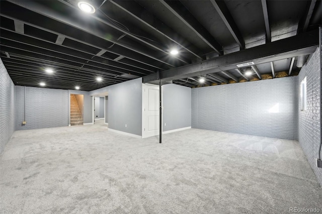 basement with carpet floors and brick wall