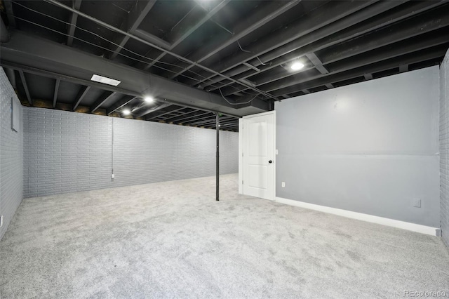 basement with carpet and brick wall