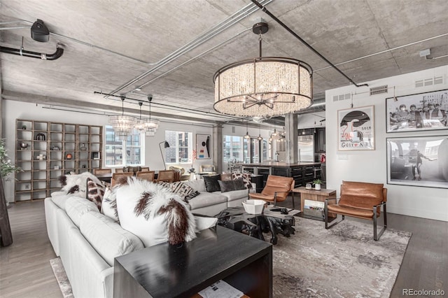 1735 19th St Unit 6D, Denver, CO 80202 - living room with a chandelier, wood finished floors, and baseboards
