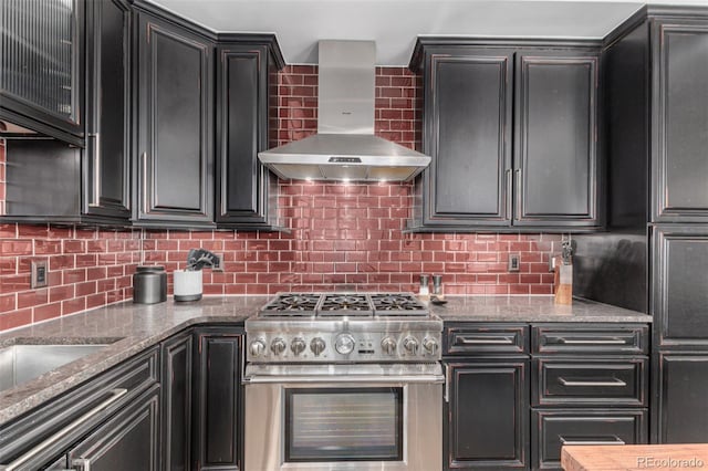 1735 19th St Unit 6D, Denver, CO 80202 - kitchen featuring high end stainless steel range, wall chimney range hood, dark cabinetry, and backsplash