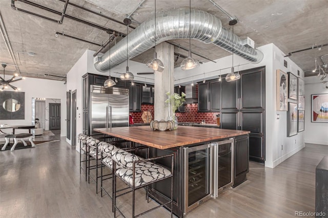 1735 19th St Unit 6D, Denver, CO 80202 - kitchen with beverage cooler, wooden counters, built in fridge, wood finished floors, and baseboards