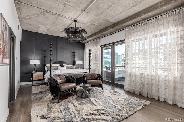 1735 19th St Unit 6D, Denver, CO 80202 - bedroom featuring wood finished floors, access to exterior, a chandelier, and a view of city
