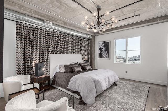 1735 19th St Unit 6D, Denver, CO 80202 - bedroom with a chandelier, wood finished floors, and baseboards