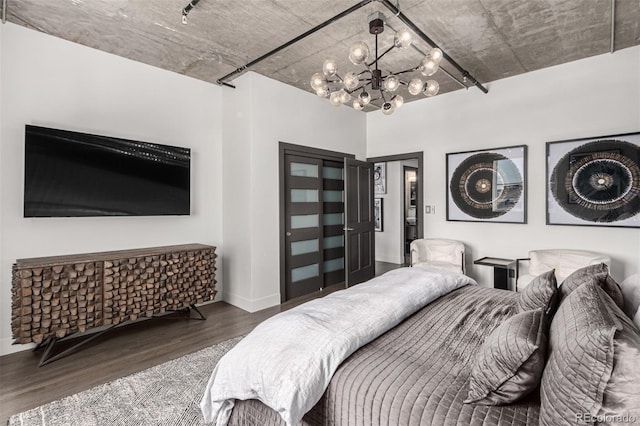 1735 19th St Unit 6D, Denver, CO 80202 - bedroom featuring wood finished floors, a chandelier, baseboards, and a closet