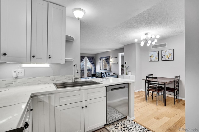 kitchen featuring a sink, visible vents, white cabinetry, dishwasher, and open shelves