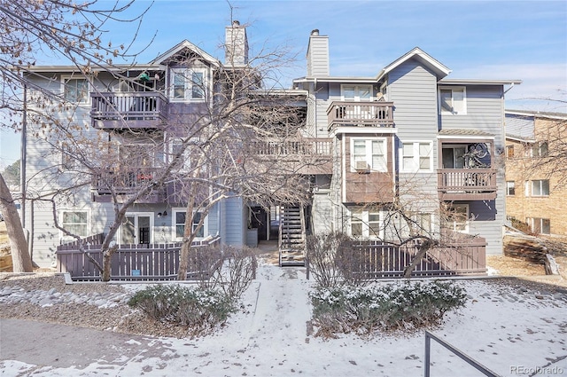 view of front of property featuring a balcony and stairs