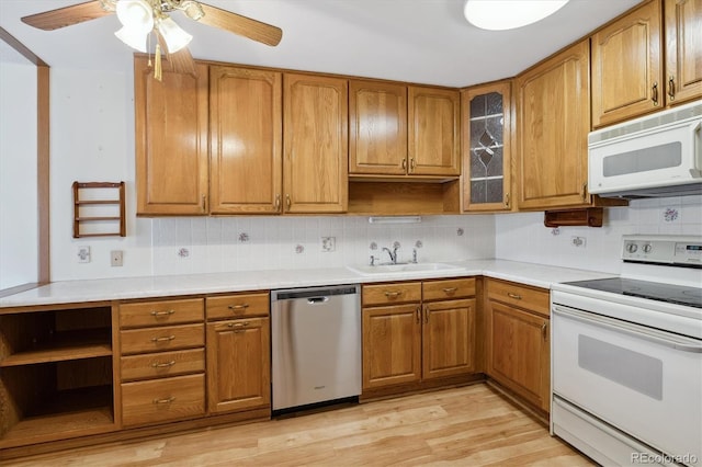 kitchen featuring backsplash, white appliances, light hardwood / wood-style floors, sink, and ceiling fan