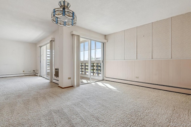 unfurnished room with a textured ceiling, carpet flooring, an inviting chandelier, and a baseboard radiator