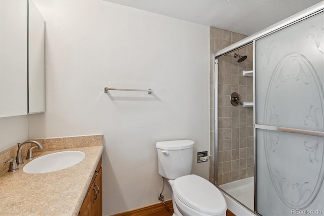 bathroom featuring vanity, toilet, and an enclosed shower